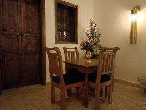 马拉喀什Riad Beni Sidel的餐桌、两把椅子和花瓶