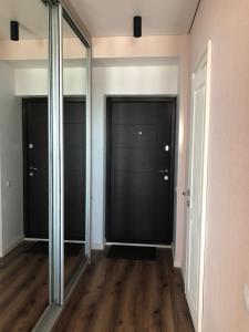 乌曼岛Однокімнатна квартира的走廊设有镜子门和木地板