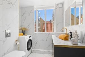 赫尔辛格Amazing apartment in the center of Helsingør的白色的浴室设有洗衣机和水槽。