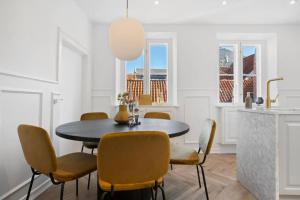 赫尔辛格Amazing apartment in the center of Helsingør的一间用餐室,配有一张黑桌子和黄色椅子