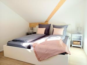马夸特施泰因Ferienwohnung Menter的卧室配有白色床和紫色和粉红色枕头。