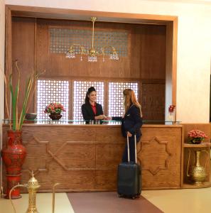 得土安伊尔雅库塔酒店的两名妇女站在带行李的酒吧