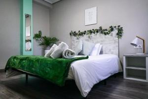 瓦伦西亚Bioparco Apartment的一间卧室配有一张绿荫遮盖的大床