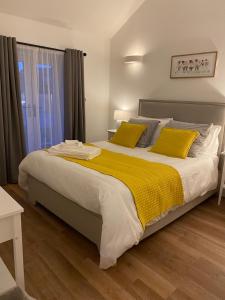普里茅斯Rural Retreat in Devon的一间卧室配有一张带黄色枕头的大床