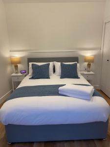 普里茅斯Rural Retreat in Devon的一张配有蓝色和白色床单及枕头的大床