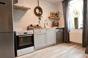 WadgassenHeimat Floral Ferienhaus的厨房配有白色橱柜和黑烤箱。