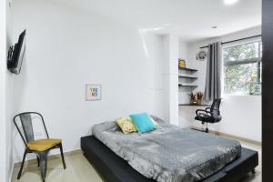 麦德林International House Co-Living的卧室配有床、椅子和窗户。