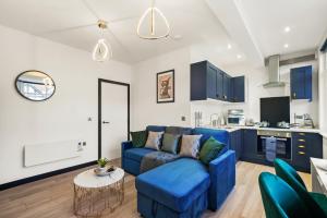 卡斯尔福德Stylish Yorkshire Gem - Sleeps 4 - Great Location的一间带蓝色沙发的客厅和一间厨房