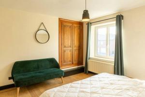 杜柏Villa Basse Cour的一间卧室设有绿色的沙发和窗户。