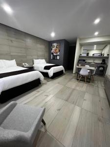 CuauhtémocMadison Suites的酒店客房配有两张床和一张书桌