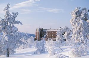  Högfjället萨勒恩斯阿尔卑斯山酒店的雪地中的一座建筑,有雪覆盖的树木
