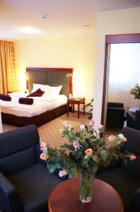 皮佐维斯维尔加卡托维兹机场酒店的配有一张床和花瓶的酒店客房