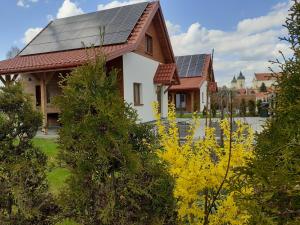 蒂科钦Przystanek Tykocin - domki gościnne w sercu Podlasia的屋顶上设有太阳能电池板的房子