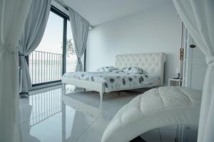 科佩尔VILA MOLET KOPER的白色的卧室设有床和大窗户