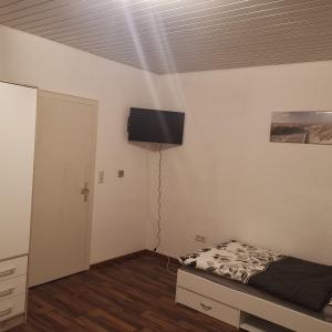 代特莫尔德Ferienunterkunft Sson的卧室配有一张床和壁挂式平面电视。