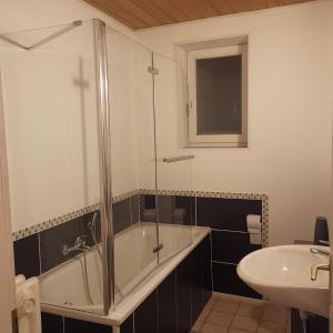 代特莫尔德Ferienunterkunft Sson的带淋浴、浴缸和盥洗盆的浴室