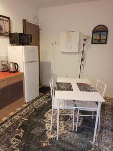 迈松阿尔福Ivone guest的厨房配有白色的桌椅和冰箱。