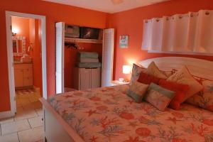 德斯坦Lazy Palm Heart Of Destin Spring Break Family Beach Vacation!的一间卧室配有一张带橙色墙壁的大床