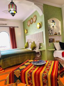 Akhendachou nʼAït Ouffi迪萨蒂尼宾馆的一间卧室配有两张床、镜子和一张四柱床