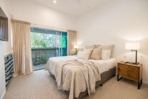 拜伦湾Swell Byron Bay - Opposite the Belongil Beach的一间卧室设有一张床和一个大窗户