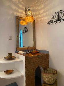 Akhendachou nʼAït Ouffi迪萨蒂尼宾馆的一间带镜子和砖砌壁炉的浴室