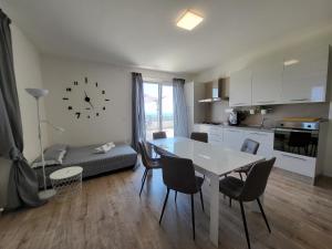 朱利亚诺瓦Villa Lida Apartment in collina con ampio terrazzo vista mare的厨房以及带桌椅的起居室。