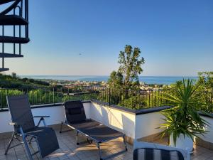朱利亚诺瓦Villa Lida Apartment in collina con ampio terrazzo vista mare的阳台配有椅子,享有海景。