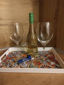 VoždivacStudio Sunset的桌子上放有一瓶葡萄酒和两杯酒