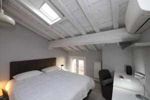摩德纳Loggia del Tenore Suite的卧室设有一张白色大床和一扇窗户。