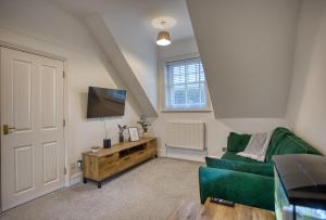 福克斯通1 or 2 bed in Folkestones West End的客厅配有绿色沙发和平面电视