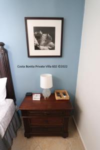 库莱布拉Costa Bonita Private Villa 602的一张桌子,上面有灯,放在床边