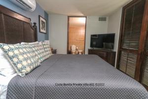 库莱布拉Costa Bonita Private Villa 602的一间卧室配有一张带枕头的床和一台电视