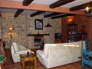 Herrera de AlcántaraFinca Dehesa Tres Riveros的客厅配有2张白色沙发和壁炉