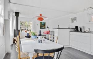 伦讷2 Bedroom Lovely Home In Rnne的厨房以及带白色桌椅的用餐室。
