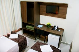 戈亚尼亚Hotel Belugi的配有书桌和电视的酒店客房