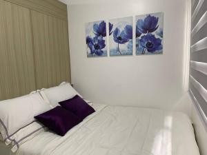 马尼拉Katei elegantly designed 1-bedroom facing amenity的客房内的白色床和紫色枕头