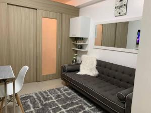 马尼拉Katei elegantly designed 1-bedroom facing amenity的客厅配有黑色沙发和桌子