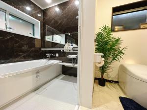 京丹后市Japanese style hotel Morigen的带浴缸、卫生间和盥洗盆的浴室
