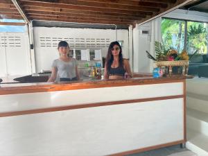 Haad Chao Phao哈超帕度假村的两名妇女站在厨房的柜台后面