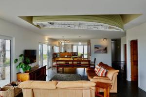 Bream CreekWaterfront 'Jemadda' Family Lodge的带沙发的客厅和用餐室