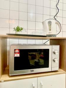 马西The D Carlton HomeStay 2BR的厨房的架子上设有微波炉