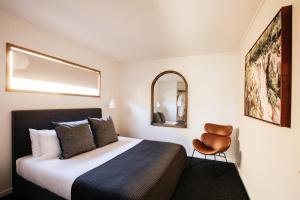 阿勒达拉Cupitt's Estate Villas的配有一张床和一把椅子的酒店客房