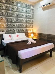 钦奈MARINA PALACE的一间卧室,配有一张床和一堵板墙