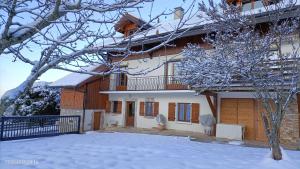 Viuz-en-SallazGîte Cœur de Haute-Savoie的前面有雪盖的房子