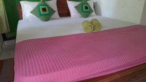 哈伯勒内Wild View Stay的一张床上有粉红色和绿色的毯子