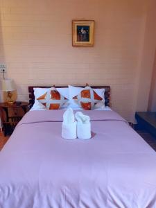 甘烹碧Bunraksa Resort的一张白色的床,上面有两双白鞋
