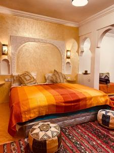 Akhendachou nʼAït Ouffi迪萨蒂尼宾馆的一间卧室配有一张大床和彩色床罩