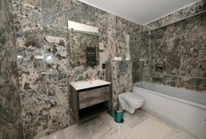 普雷代亚尔R&B Studio的浴室配有卫生间、浴缸和水槽。