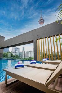 吉隆坡Santa Grand Signature Kuala Lumpur的水边带桌椅的游泳池