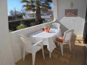 贝纳吉Apartamento Neptuno的棕榈树阳台的白色桌椅